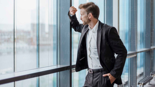 Person reflecting on career path while overlooking a city skyline at sunset.